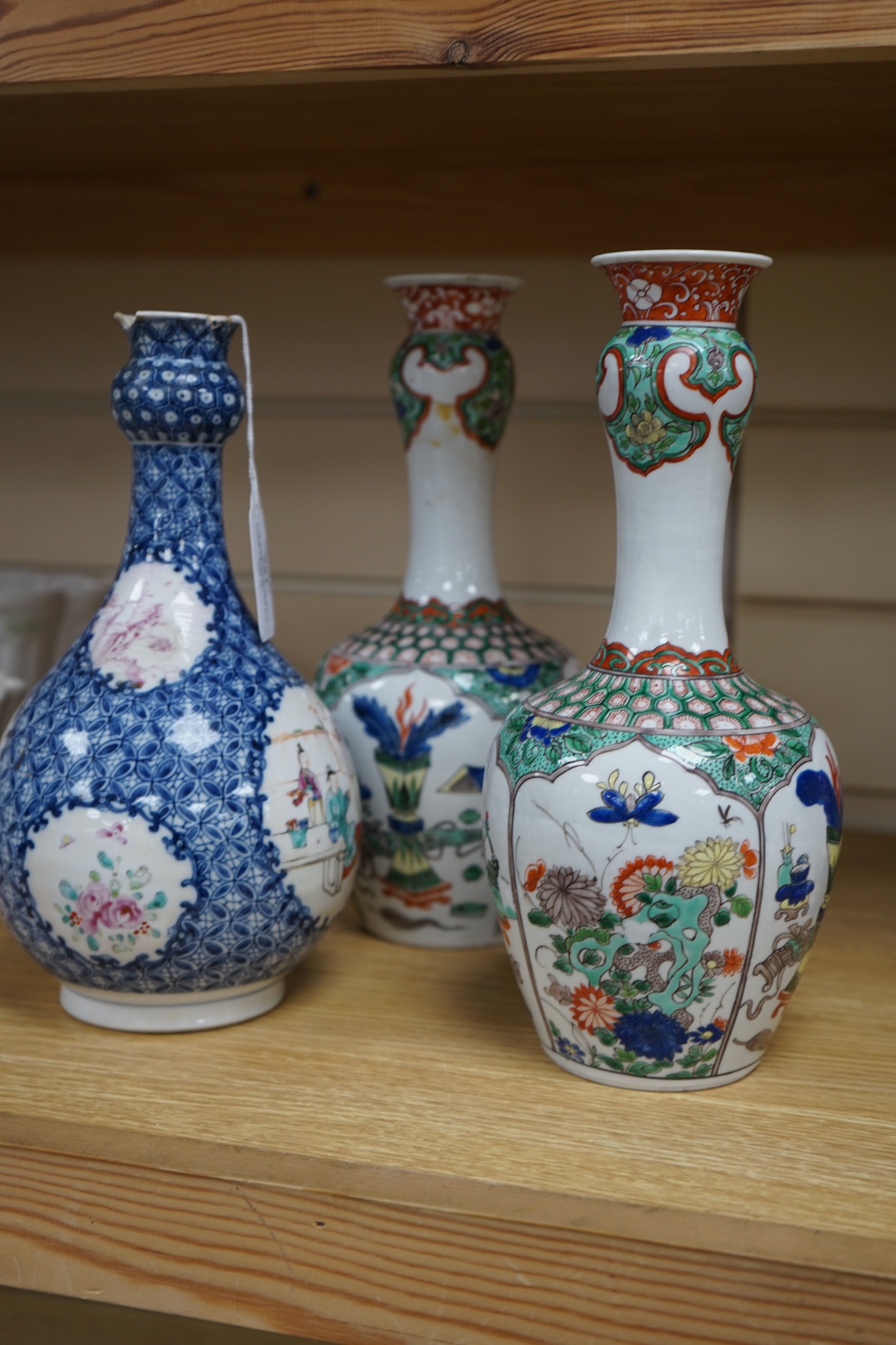 A pair Samson of Paris vases in the Chinese famille verte style and a Chinese Qianlong famille rose garlic neck vase with blue panelling motif, tallest 26cm